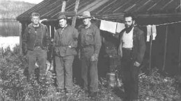 Bush pilot George Smith, left, with Harry Buckles, second from left, a local prospector and the camp cook. The picture was taken during the staking rush of early 1953, near what would become the Nordic mine in the middle belt of the "Z" pattern sedimentary contact.