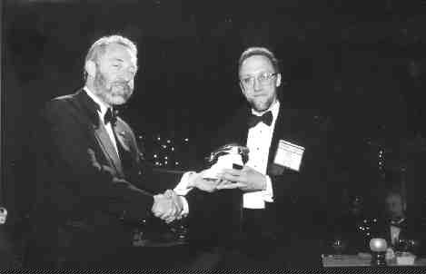 Tracey Savein, South Paw productionsDonald Birak of Hudson Bay Mining & Smelting receives the Prospector of the Year Award from John Steele, president of the PDAC.