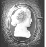 This cameo brooch from the 19th century is made from grey and white agate set in gold with black enamel detail.
