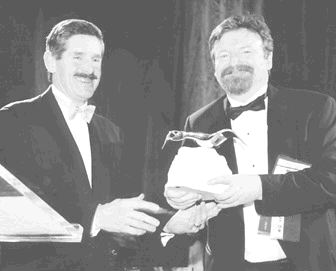 Robert McEwen (left) of Goldcorp receives the Viola MacMillan Award for Developer of the Year for 2001 from Mark Smith of First Associates.