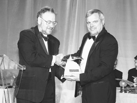 PDAC President William Mercer presents the Bill Dennis Prospector of the Year award to Alex Davidson, senior vice-president of exploration with Barrick Gold.