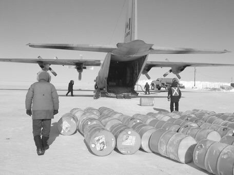 Workers unload fuel and supplies from a Hercules C-130 transport aircraft at the Igloolik Airport.