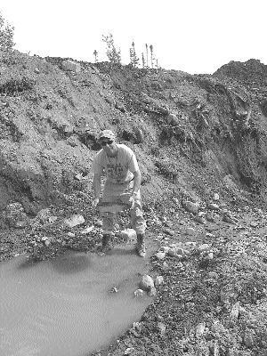 Calvin Keats, a prospector working for Crosshair, pans oxidized subcrop from Titan trench 7.