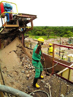 A worker directs ore into the primary crusher at Anvil's Dikulushi processing plant.