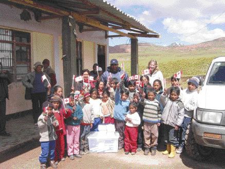 Gitennes Exploration geologists Jorge Zapata and Gayle McCleery donate a set of encyclopedias to school children in Llasca, Peru. Gitennes is exploring the nearby Tucumachay gold project.