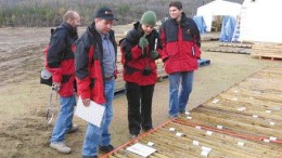 Sherwood Copper President Stephen Quin (second from left) looks at core from the Minto copper-gold project with members of the media and analysts during a recent tour of the project.