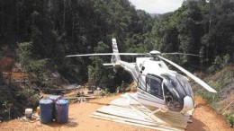 By Stephen StakiwA helicopter on Petaquilla Minerals' Molejon gold project. A drill rig downslope is visible in the background.