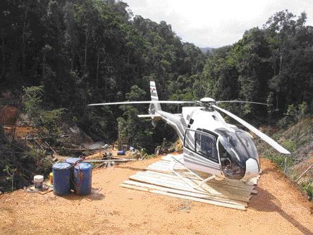 By Stephen StakiwA helicopter on Petaquilla Minerals' Molejon gold project. A drill rig downslope is visible in the background.