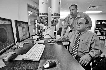 SGS-LAKEFIELDMineral and metallurgical lab SGS-Lakefield recently opened a new facility in Lakefield, Ont., as part of what the company calls its Advanced Mineralogy Network. Here, Paul Gottlieb (front), developer of the QEMSCAN mineralogical analysis instrument -- the cornerstone of the Advanced Mineralogy Network -- demonstrates QEMSCAN with Chris Gunning, an SGS mineralogist.