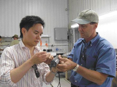 BY SUSAN KIRWINAaron Chan of Canaccord Capital gets a lesson from Alexandria Minerals president Eric Owens on how to use a hand lens to examine drill core.