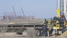 A new drill rig arrives in Kazakhstan, with Uranium One's South Inkai plant in the background.