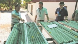 Platinum Group Metals' project manager Andre du Plessis (left), company president and CEO Michael Jones (centre) and London-based investment manager, Hugo Worth, review core at the company's exploration facility in the Bushveld Complex of South Africa.