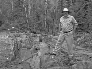 Dean Cutting, project manager for Houston Lake Mining's Dogpaw Lake gold property, poses on a gold mineralized outcrop. The property, which is near Kenora, Ont., is littered with small pods of near-surface mineralization.