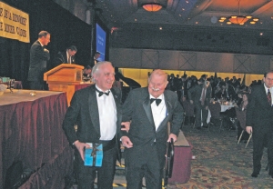 Canadian Mining Hall of Fame inductee Prof. Donald "Digger" Gorman (right) is escorted from the podium by Jeff Fawcett, professor emeritus in the department of geology at the University of Toronto.