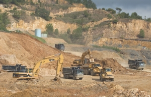 Caterpillar equipment is used to stockpile topsoil at Barrick Gold's Pueblo Viejo gold project in the Dominican Republic. The global economic slowdown has cut into Caterpillar's profits, prompting the company to announce layoffs of nearly 24,000 people.