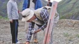 Geologist Todd McCracken (front) takes a reading at a drill hole while Prophecy Resource CEO John Lee (left) and adviser John Morganti (right) look at assay results at the Wellgreen nickel-copper-PGM project.