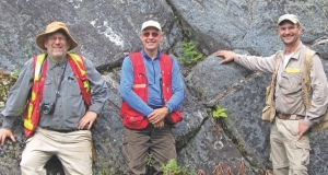 In front of a large outcrop of high-grade coarse-grained specular hematite at Champion Minerals' Fire Lake North iron project in northeastern Quebec, from left: Jean Lafleur, director and technical adviser; Bruce Mitton, senior project geologist; and Jeff Hussey, vice-president of exploration.