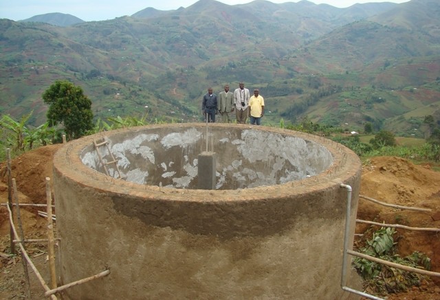Banro Foundation staff with the tank for a potable water system near the Twangiza gold mine project in the eastern DRC. It serves 18,000 people and consists of 19,000 metres of piping.