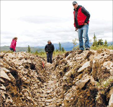 Kaminak Gold VP of exploration Tim Smith (far right) and colleagues explore a trench at the Coffee gold project in the Yukon. Photo by Ian Bickis