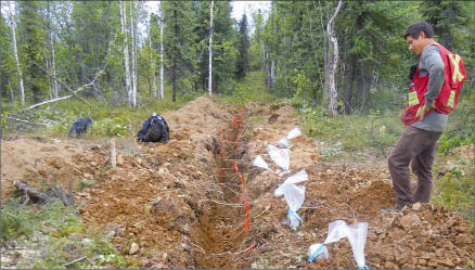 Geologist Dan Gabriel looks at a trench at Ethos Capital's Betty gold project in the Yukon's White Gold district. Photo by Ethos Capital