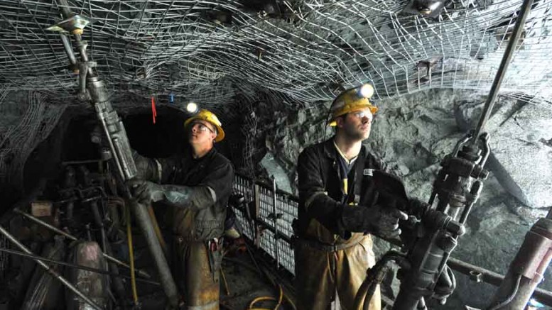 Workers bolting wire mesh to the rock face to secure an access way in QMX Gold's Lac Herbin gold mine in Val-d'Or, Quebec. Source: QMX Gold