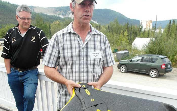 GroundTruth Exploration president Shawn Ryan holds an exploration drone in Dawson City, Yukon, as Taku Gold director Mark Fekete looks on. Photo: Gwen Preston