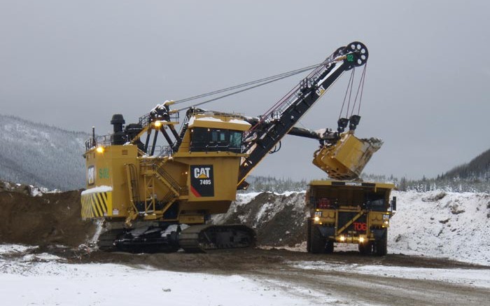 A shovel dumps a load into a haul truck as Thompson Creek strips overburden in preparation to start mining the North pit at Mt Milligan. Credit: Thompson Creek Metals