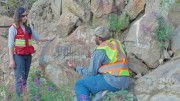 Victoria Gold project geologist Helena Kuikka and Yukon Geological Survey geologist Patrick Sack discuss an outcrop at the Olive zone, part of Victoria's Dublin Gulch gold project in Yukon. Photo by Gwen Preston.