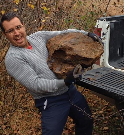 Visible Gold Mines president and CEO Martin Dallaire hoists a high-grade boulder at the 167 Extension gold project in Quebec's James Bay region. Credit: Visible Gold Mines