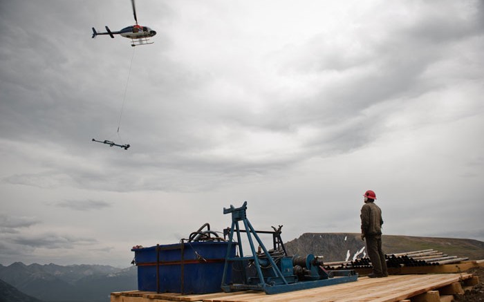 A helicopter drops off equipment to a drill platform at Tower Resources' JD project in B.C. Credit: Tower Resources