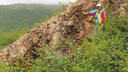 A field worker stands by the outcropping Shumagin vein at Redstar Gold's Unga gold project in Alaska. Credit: Redstar Gold