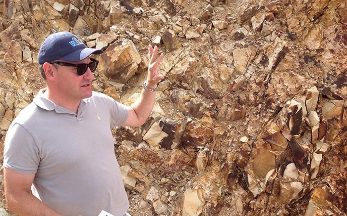 At an outcrop along the drill road, West Kirkland Mining president and CEO Michael Jones explains the geology seen at the Hasbrouck gold project. Credit: Photo by Matthew Keevil.