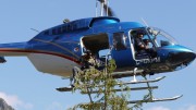 Student environmentalist Haj Bains signals to helicopter pilot Michael King after collecting a treetop sample in west-central British Columbia. Photo credit: Bruce Madu