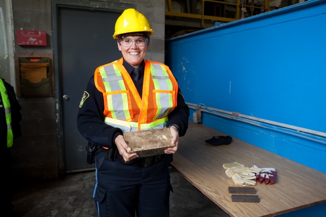 An Ontario Provincial Police officer poses with a freshly poured gold bar at the Mishi gold mine opening in Ontario in 2012. Credit: Wesdome Gold Mines