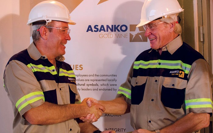 Peter Breese (left), Asanko Gold's president and CEO, and Colin Steyn, chairman, shake hands over a gold bar from the Asanko gold mine in Ghana. Credit: Asanko Gold