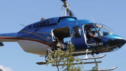 Student Haj Bains signals to helicopter pilot Michael King after collecting a treetop sample in west-central British Columbia, as part of Geoscience BC’s TREK survey. Photo by Bruce Madu.