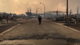 A Royal Canadian Mounted Police walking along a fire devastated street in Fort McMurray, Alberta. Credit: RCMP Alberta