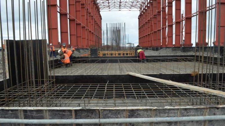 Workers building the main plant at Silver Bear Resources’ Vertikalny Central silver mine in Russia’s Far East. The conveyor support base is seen in the foreground with the mill feed bin foundation behind it and ball mill foundation in the background. Credit: Silver Bear Resources.