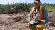 Marathon Gold prospector Dave Galley examines visible gold in coarse cubic pyrite from large quartz-tourmaline-pyrite at the Sprite deposit at the Valentine Lake gold property in Newfoundland.  Credit: Marathon Gold.