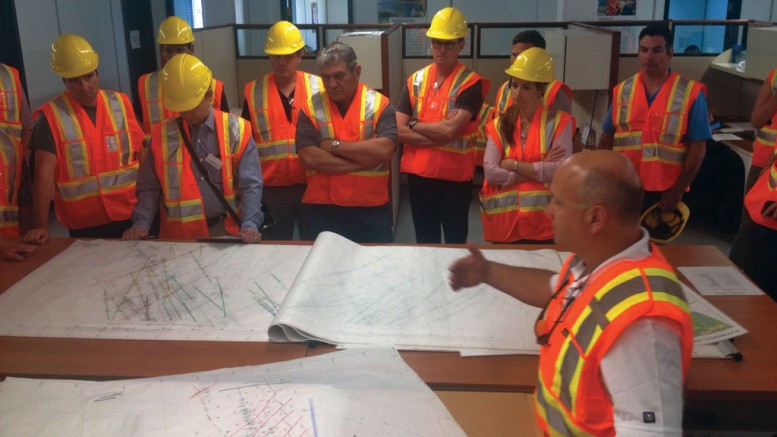 Integra Gold’s senior vice-president of exploration Hervé Thiboutot (front) explains the geology of the Triangle and No. 4 Plug gold deposits to analysts and investors during a site visit in July. Photo by Lesley Stokes.