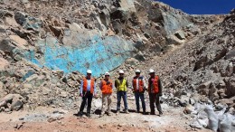 A group poses in front of visual copper at Coro Mining's Berta project in Chile. Credit: Coro Mining.