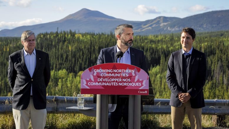 Yukon Premier Sandy Silver at the podium in Whitehorse, Yukon, on Sept. 2 to announce the $360-million Yukon Resource Gateway Project to improve roads in the Yukon, with Prime Minister Justin Trudeau (right) and Yukon Member of Parliament Larry Bagnell. Credit: CP.