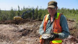 Marathon Gold prospector Dave Galley examines visible gold in coarse cubic pyrite from large quartz-tourmaline-pyrite at the Sprite deposit at the Valentine Lake gold property in Newfoundland. Credit: Marathon Gold.